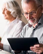 Elderly couple researching pension options online